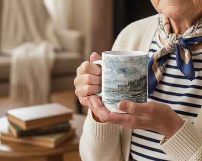 Weiße Keramiktasse mit der dicht bebauten Altstadt von Saint-Malo, dunklen Dächern und historischen Gebäuden