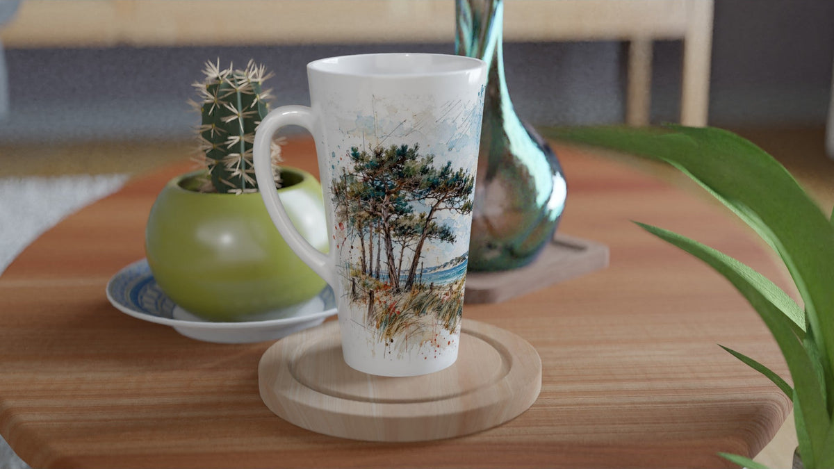 Küstenmotiv mit windgeformten Kiefern, Dünengras und blauem Meer auf einer hohen weißen Latte Tasse