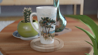 Küstenmotiv mit windgeformten Kiefern, Dünengras und blauem Meer auf einer hohen weißen Latte Tasse