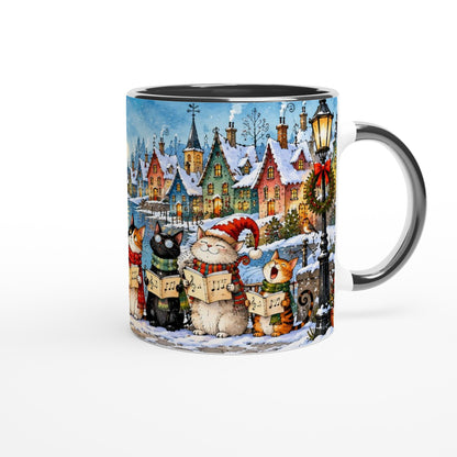 Weiße Keramiktasse mit schwarzem Henkel und singenden Katzen mit Notenblättern vor Weihnachtsbaum, Geschenken und verschneiter Winterlandschaft