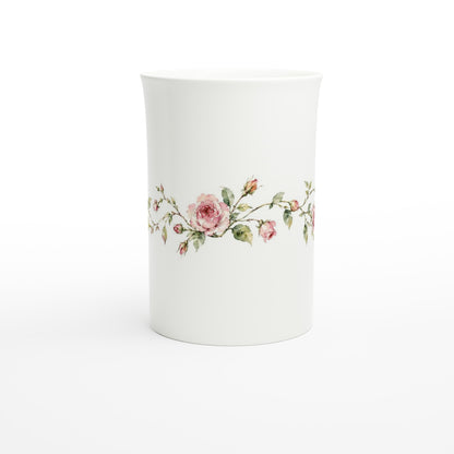 Schlanke weiße Porzellantasse mit zarten rosa Rosen und locker geschwungenen grünen Rosenzweigen