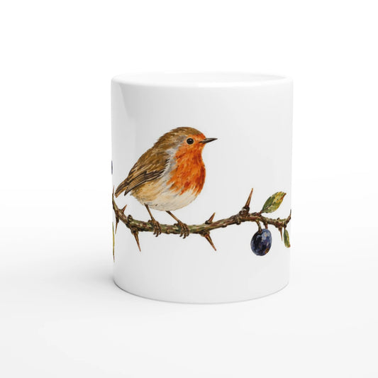Weiße Keramiktasse 330 ml mit detailreicher Illustration eines Rotkehlchens auf einem dornigen Schlehenzweig mit tiefblauen Früchten und grünen Blättern.