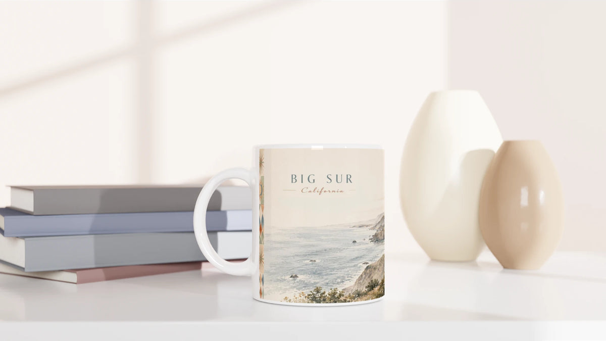 Rückseite der Big Sur California Tasse mit zwei Reisenden an einer Steinmauer vor weiter kalifornischer Berglandschaft, geschwungener Küstenstraße und Brücke im Aquarellstil
