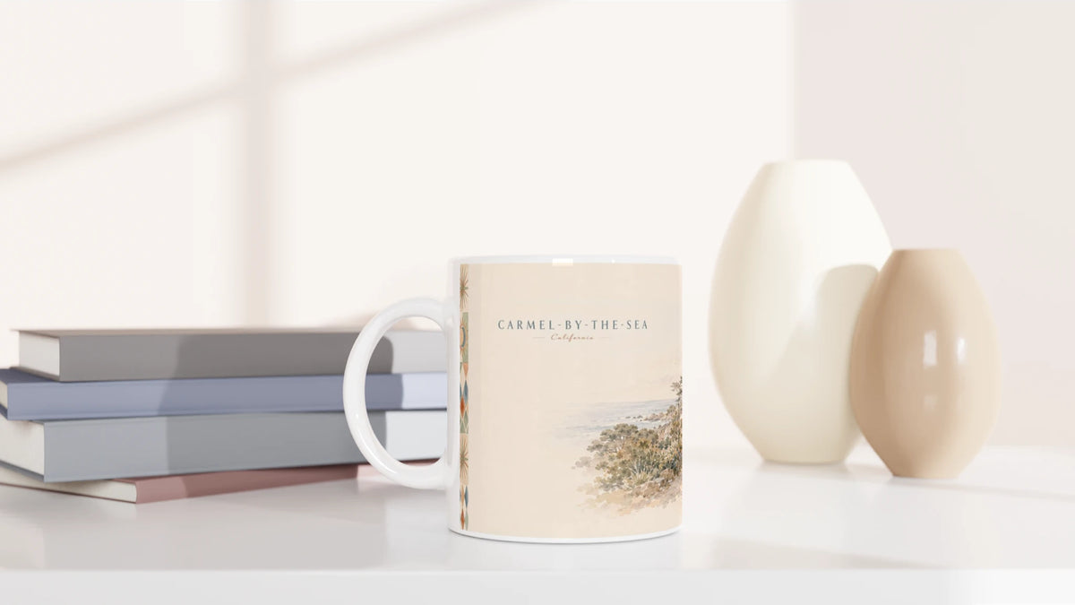 Rückseite der Carmel-by-the-Sea California Tasse mit aquarellierter Cottage-Straße, Natursteinmauern, blühenden Gärten, großen Zypressen und einem spazierenden Paar