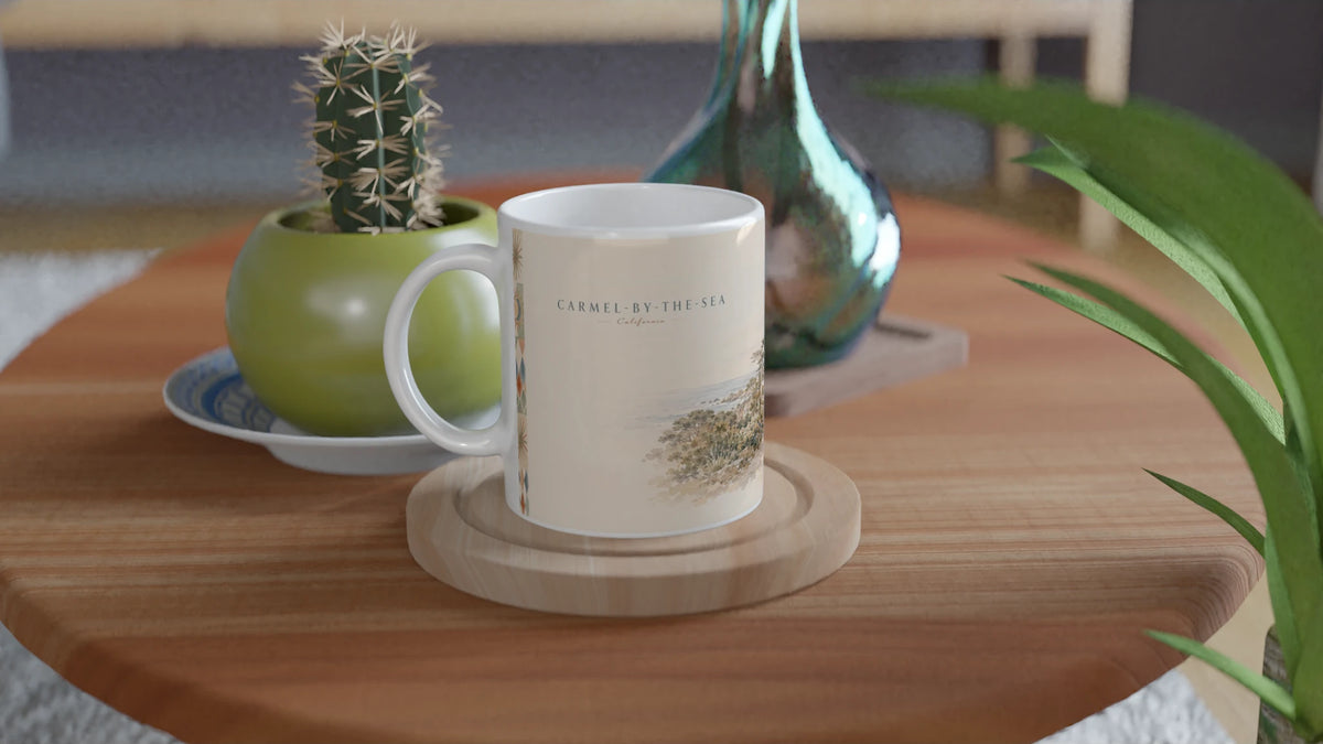 Carmel-by-the-Sea California Tasse 0,33 l mit nostalgischem Pazifikküsten-Aquarell auf einem Holztisch in einem Wohnambiente mit Kaktus, Glasvase und grüner Pflanze