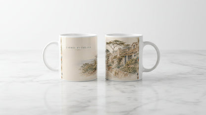 Zwei Ansichten der Carmel-by-the-Sea California Tasse zeigen das Küstenmotiv mit Schriftzug sowie die gegenüberliegende Szene mit Cottages, Natursteinmauern, Zypressen und blühenden Gärten