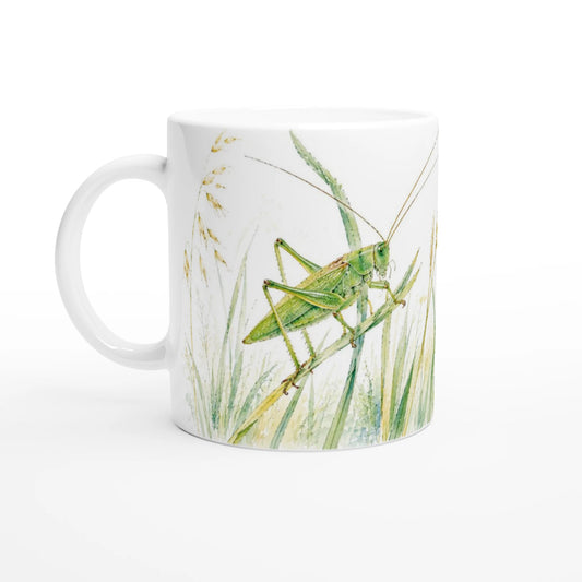 Grünes Heupferd Tasse 330 ml mit großem grünem Heupferd zwischen hohen Halmen, Gräsern und Ähren in einer leichten Aquarellillustration.