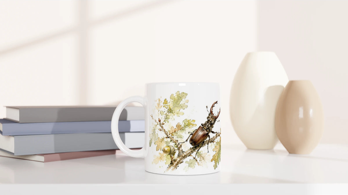 Keramiktasse aus der Wild Companions Collection mit braunem Hirschkäfer auf Eichenast, Eichenlaub und Eicheln im feinen Aquarellstil.