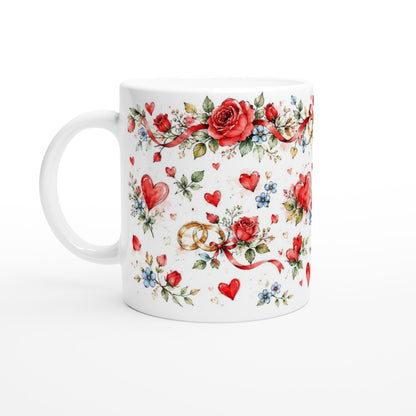 Romantisches Hochzeitsmotiv auf einer weißen Tasse: Eheringe, Rosen und Herzen bilden eine zarte Aquarellkomposition für besondere gemeinsame Momente.