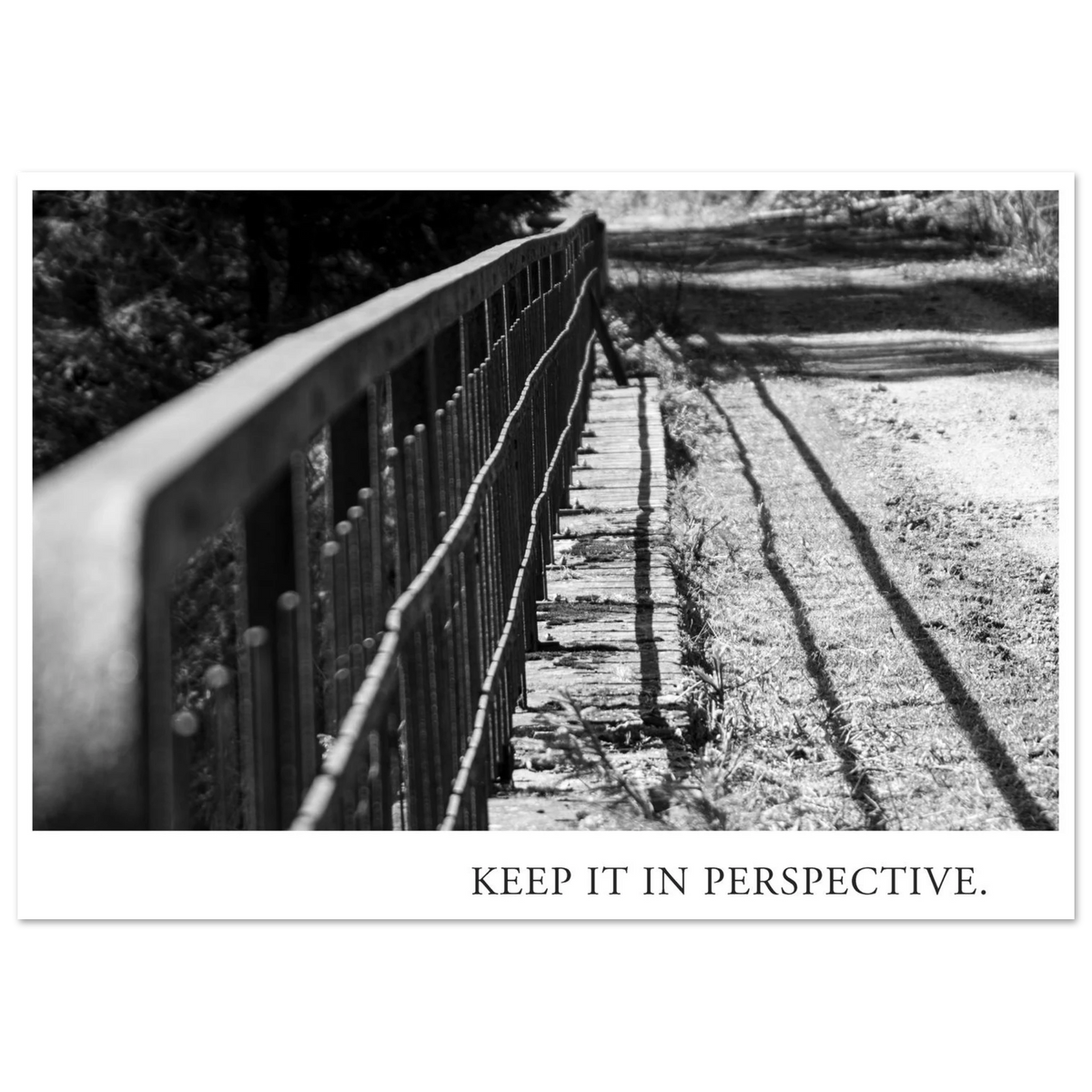 Schwarzweiß Fotografie KEEP IT IN PERSPECTIVE mit diagonal verlaufendem Metallgeländer, starkem Licht und langen Schatten als Fine Art Kunstdruck von Mano et Arte