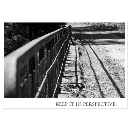 Schwarzweiß Fotografie KEEP IT IN PERSPECTIVE mit diagonal verlaufendem Metallgeländer, starkem Licht und langen Schatten als Fine Art Kunstdruck von Mano et Arte