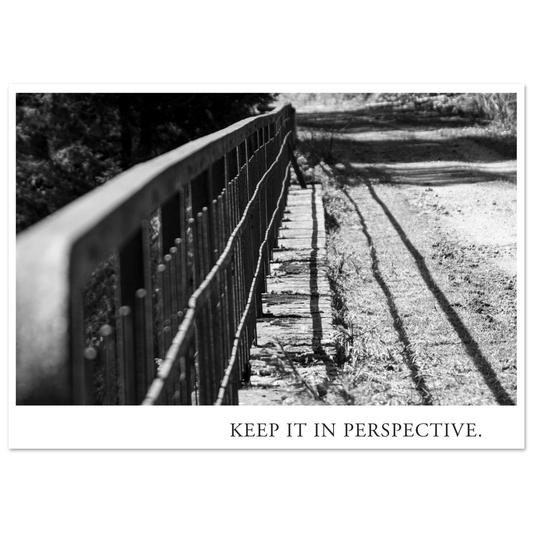 Schwarzweiß Fotografie KEEP IT IN PERSPECTIVE mit diagonal verlaufendem Metallgeländer, starkem Licht und langen Schatten als Fine Art Kunstdruck von Mano et Arte