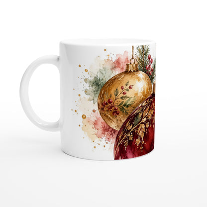 Keramiktasse zur Weihnachtszeit mit glänzend wirkenden Kugelmotiven in traditionellen Rot-, Grün- und Goldtönen sowie dekorativen Tannenzweigen auf weißem Hintergrund.