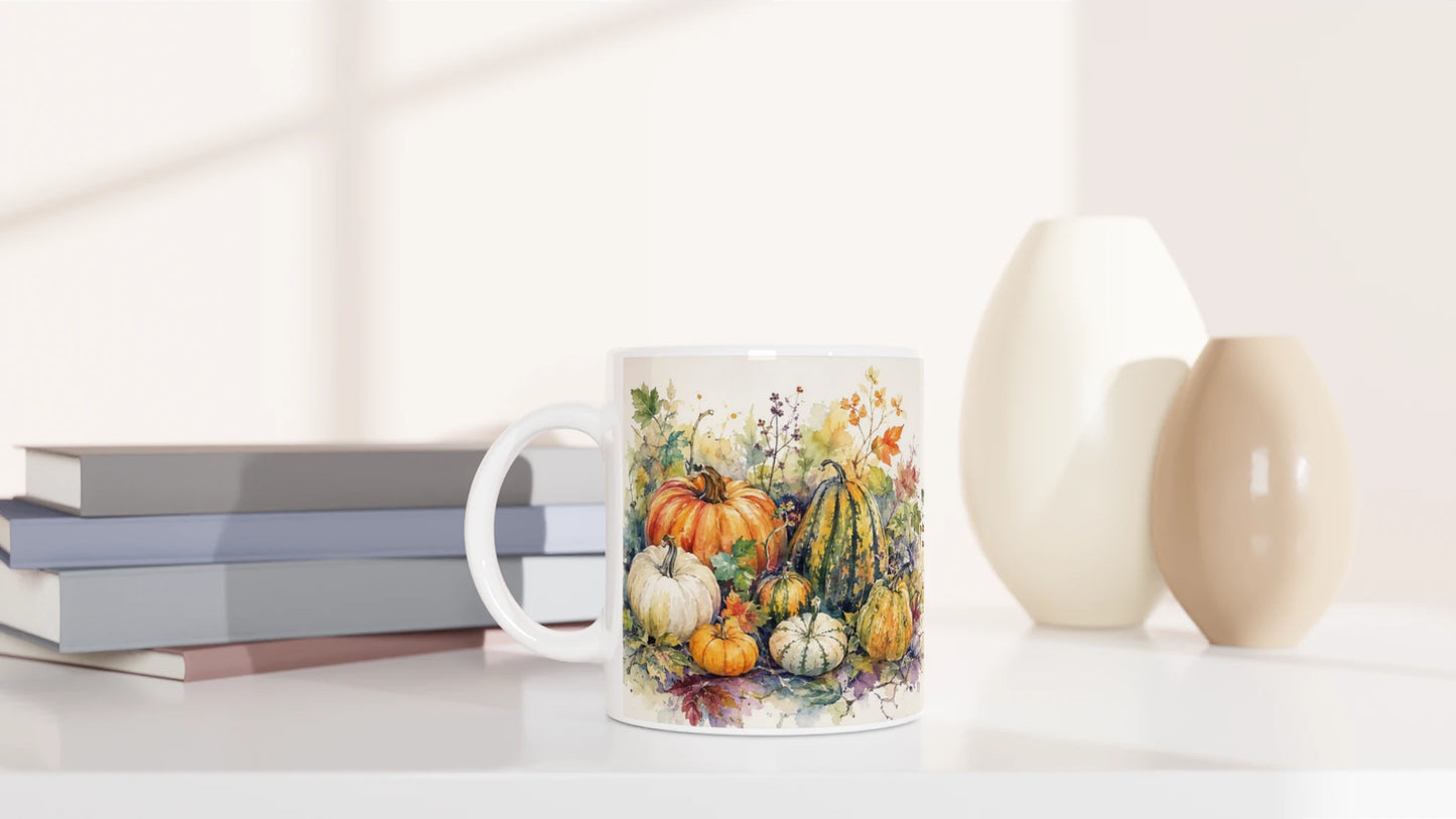 Herbstliche Tasse mit weißen, grünen und gemusterten Zierkürbissen zwischen Blättern, Ranken und kleinen Blüten