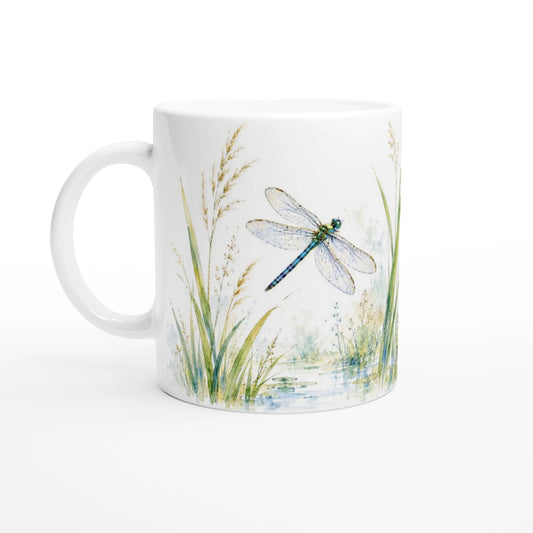Libelle Wasseriris Tasse 330 ml mit blau-grün schimmernder Libelle über einer kleinen Wasserfläche, umgeben von Schilf und feinen Gräsern im Aquarellstil.