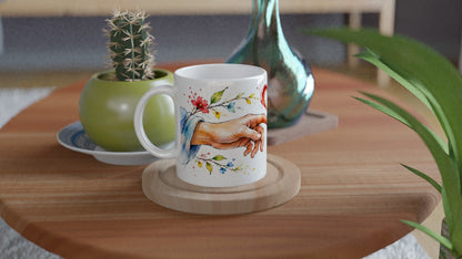 Liebesgeschenk in Form einer 330-ml-Keramiktasse mit zwei Händen und rotem Herzen. Ein Motiv für besondere Menschen.