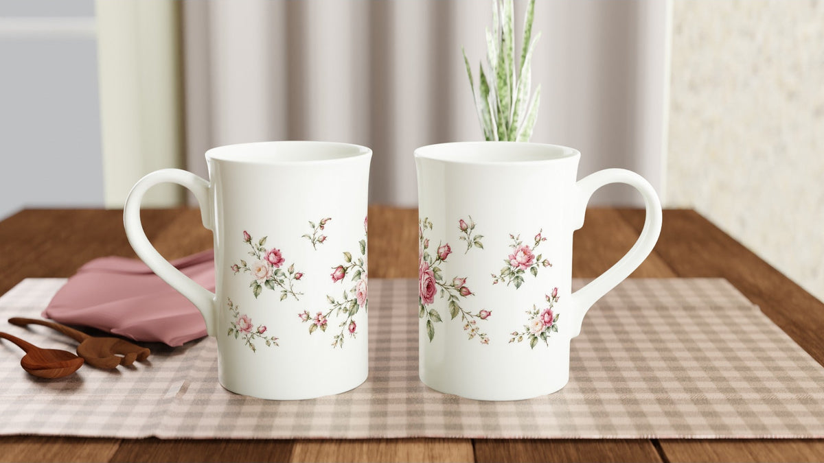 Rosen Porzellantasse mit botanischer Illustration in sanften Rosa-, Creme- und Grüntönen. Zarte Blüten und Rosenknospen bilden eine klassische, nostalgische Blumenkomposition.