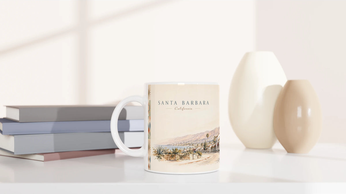 Santa Barbara California Tasse 0,33 l mit Küstenpanorama, Bergen und Palmen in einem hellen minimalistischen Wohnambiente neben Büchern und dekorativen Vasen