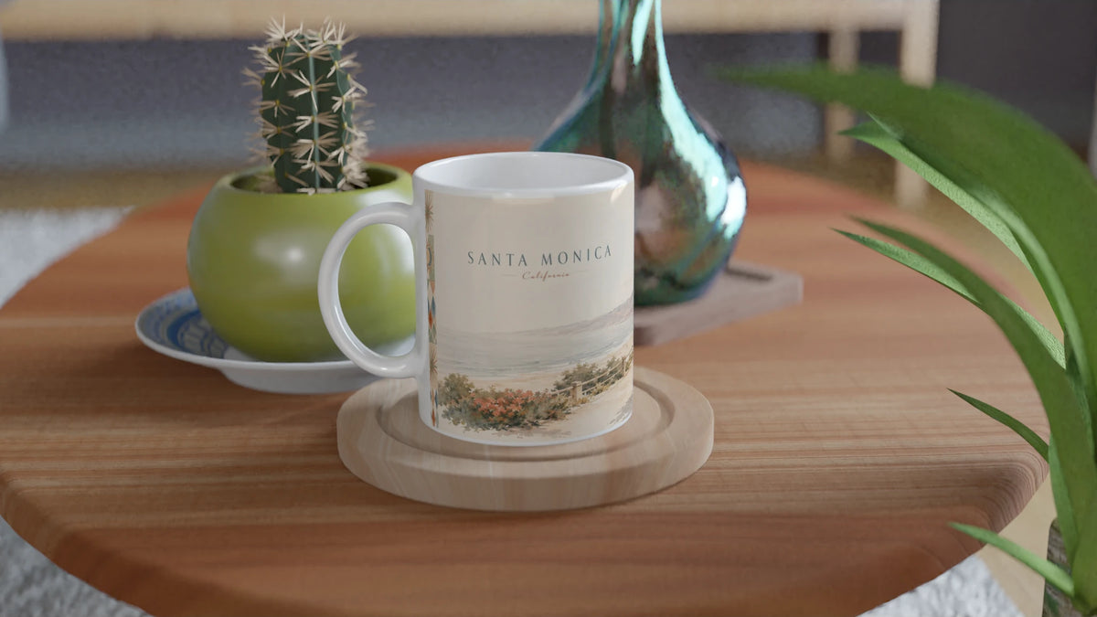 Santa Monica California Tasse 0,33 l mit heller Küstenillustration in einem minimalistischen Wohnambiente neben gestapelten Büchern und cremefarbenen dekorativen Vasen