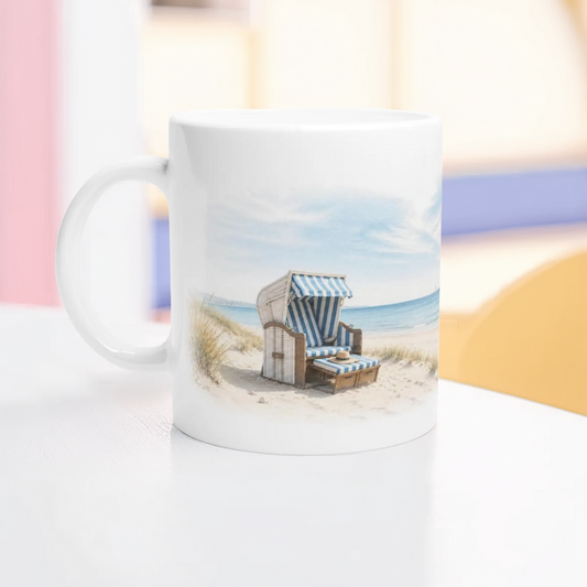 Strandkorb Tasse 330 ml mit blau-weißem Strandkorb, Meer, Dünen und hellem Aquarellmotiv auf weißer Keramik.