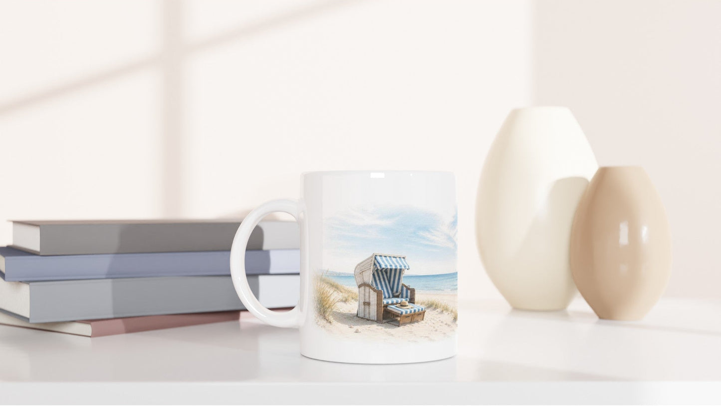 Strandkorb Keramiktasse mit hellem Aquarelldesign, viel Weißraum und nordischer Strandatmosphäre.