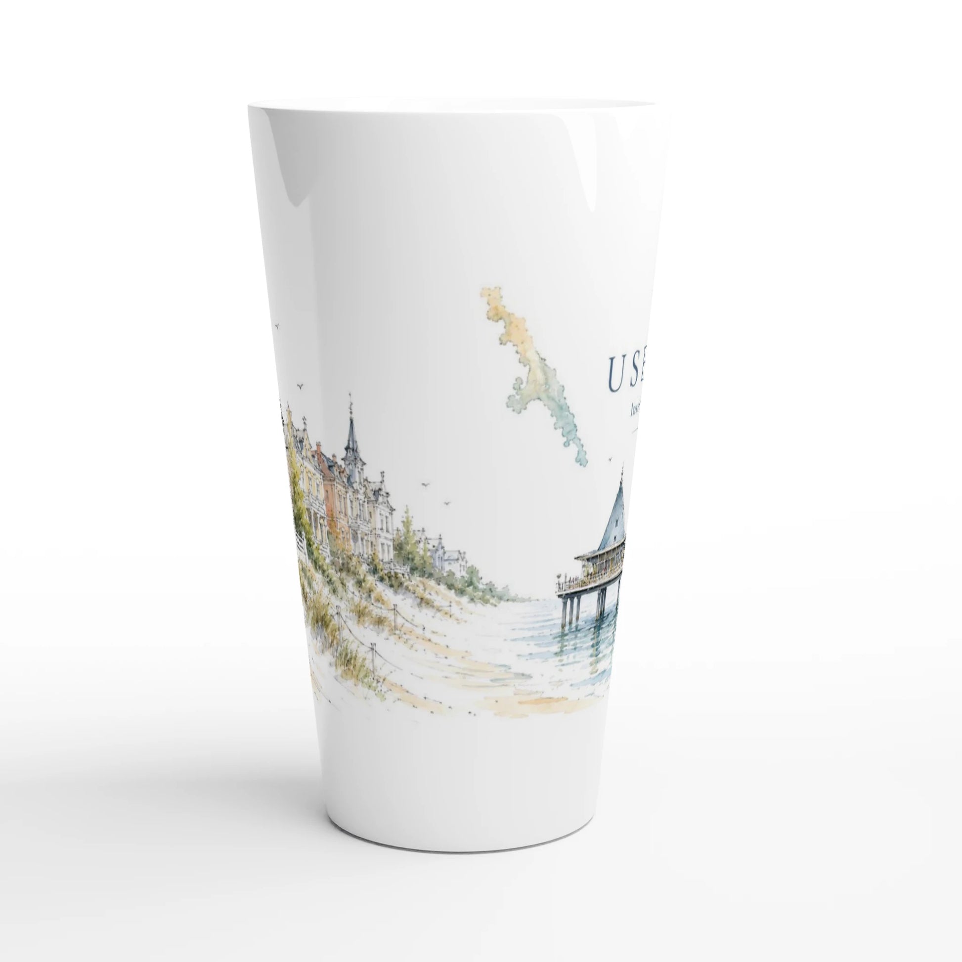 Usedom Latte Tasse mit historischer Bäderarchitektur hinter hellen Dünen, Strandgras und feinen Aquarellfarben