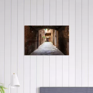 Aluminiumbild mit historischer, schmaler Gasse in Siena unter einem dunklen Torbogen, warmen Backsteinwänden und hellem Ausgang im Hintergrund.